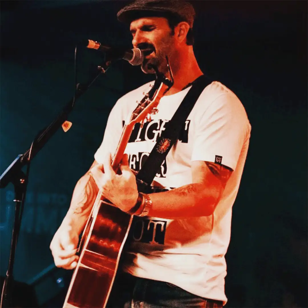 Photo of Greg playing guitar